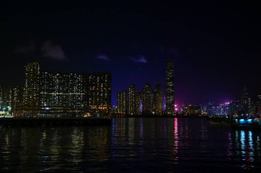 Kowloon 'dan Hong Kong Adası' nın gece manzarası. Geceleri Hong Kong şehir manzarası ve deniz manzarası. Doğa ve şehir manzarası.
