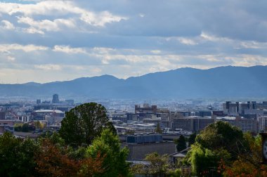 Kyoto şehrinin manzarası mavi gökyüzü ve Japonya 'nın Kyoto kentindeki kiyomizu-dera tapınağındaki ağaçlarla yükseliyor. Japonya 'nın Kansai bölgesinde önemli bir turistik ilgi merkezi. Seyahat konsepti. Japon şehir manzarası.