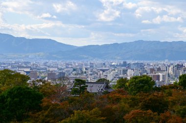 Kyoto şehrinin manzarası mavi gökyüzü ve Japonya 'nın Kyoto kentindeki kiyomizu-dera tapınağındaki ağaçlarla yükseliyor. Japonya 'nın Kansai bölgesinde önemli bir turistik ilgi merkezi. Seyahat konsepti. Japon şehir manzarası.