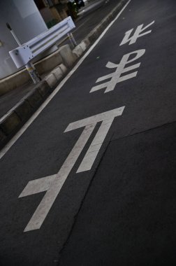 Japonya 'nın yol yüzeyindeki dur levhasındaki harfler. Japon sokak tabelası. Çeviri: Japonca Kanji mektubu Araba sürücülerine durmalarını söylüyor.