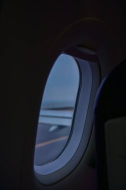 Uçak penceresinden, çarpıcı gökyüzü manzarası ve uçak kanadı olan manzaraya bakıyorum. Seyahat ve ulaşım kavramı.