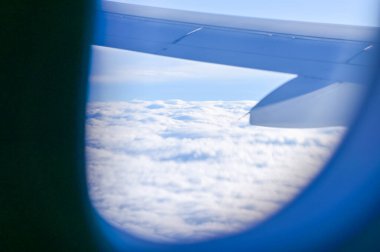 Uçak penceresinden, çarpıcı gökyüzü manzarası ve uçak kanadı olan manzaraya bakıyorum. Seyahat ve ulaşım kavramı.