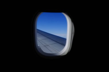 Uçak penceresinden, çarpıcı gökyüzü manzarası ve uçak kanadı olan manzaraya bakıyorum. Seyahat ve ulaşım kavramı.
