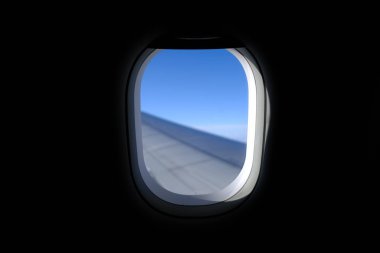 Uçak penceresinden, çarpıcı gökyüzü manzarası ve uçak kanadı olan manzaraya bakıyorum. Seyahat ve ulaşım kavramı.