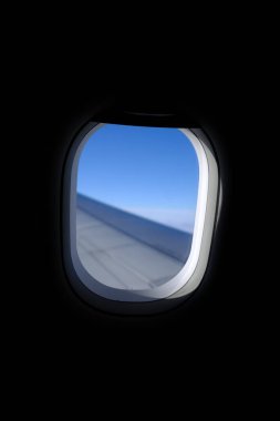 Uçak penceresinden, çarpıcı gökyüzü manzarası ve uçak kanadı olan manzaraya bakıyorum. Seyahat ve ulaşım kavramı.