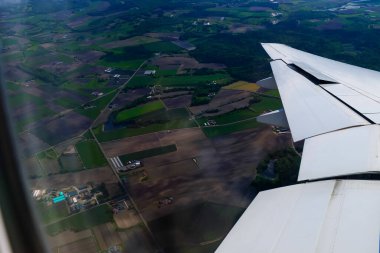 Uçak penceresinden, çarpıcı gökyüzü manzarası ve uçak kanadı olan manzaraya bakıyorum. Seyahat ve ulaşım kavramı.