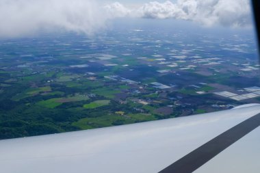 Uçak penceresinden, çarpıcı gökyüzü manzarası ve uçak kanadı olan manzaraya bakıyorum. Seyahat ve ulaşım kavramı.