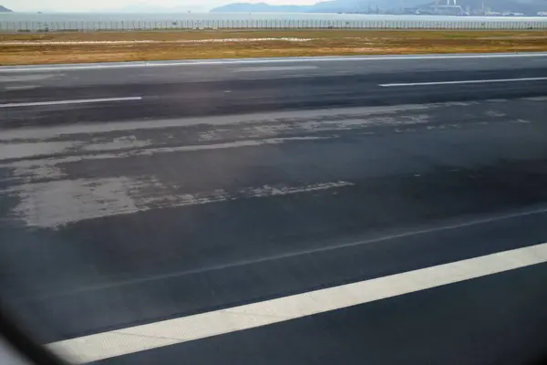 İniş sahnesinin uçak penceresinden bakıyorum. Havaalanı önlüğü sahnesi. Seyahat ve ulaşım kavramı.