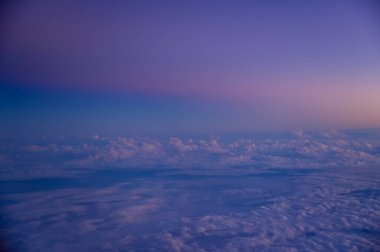 Gün batımı gökyüzü ile uçak penceresinden bakıyorum. Romantik gökyüzü, altın saatler, bulutlu renkli günbatımı gökyüzü. Çarpıcı bulutlar ve gökyüzü. Doğa konsepti. Arkaplan kullanımı için.