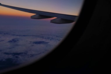 Gün batımı gökyüzü ile uçak penceresinden bakıyorum. Romantik gökyüzü, altın saatler, bulutlu renkli günbatımı gökyüzü. Çarpıcı bulutlar ve gökyüzü. Doğa konsepti. Arkaplan kullanımı için.