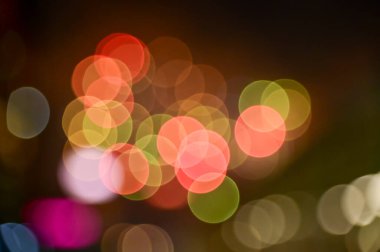 Gece gökyüzünde renkli havai fişeklerin Bokeh etkisi. Gerçek havai fişek arka planı. Siyah arka planda parlayan gerçek havai fişeklerin soyutlanması. Kutlama için parlayan havai fişek gösterisi.