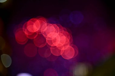 Gece gökyüzünde renkli havai fişeklerin Bokeh etkisi. Gerçek havai fişek arka planı. Siyah arka planda parlayan gerçek havai fişeklerin soyutlanması. Kutlama için parlayan havai fişek gösterisi.