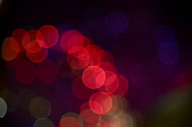 Gece gökyüzünde renkli havai fişeklerin Bokeh etkisi. Gerçek havai fişek arka planı. Siyah arka planda parlayan gerçek havai fişeklerin soyutlanması. Kutlama için parlayan havai fişek gösterisi.