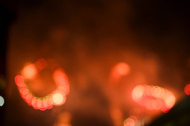 Gece gökyüzünde renkli havai fişeklerin Bokeh etkisi. Gerçek havai fişek arka planı. Siyah arka planda parlayan gerçek havai fişeklerin soyutlanması. Kutlama için parlayan havai fişek gösterisi.