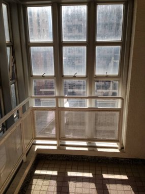 Merdiven boşluğundaki pencereden güneş ışınları. Yerdeki güneş ışınlarından gelen yumuşak çizgiler. Soyut arkaplan. Güneş ışınlarıyla aydınlık bir zemin. Yumuşak odak.