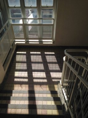 Merdiven boşluğundaki pencereden güneş ışınları. Yerdeki güneş ışınlarından gelen yumuşak çizgiler. Soyut arkaplan. Güneş ışınlarıyla aydınlık bir zemin. Yumuşak odak.