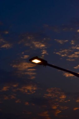 Sokak lambasına yakın çekim. Açık havada aydınlatma. Ampul. Şehirde ışıklandırma var. Lamppost konsepti. Şehir manzarası. Işıklandırma ekipmanı.