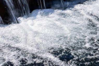 Halka açık bir parktaki şelale manzarası. Su sıçrıyor, su akıyor. Doğa konsepti.