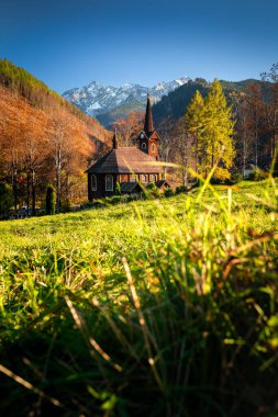 St. Anne 'in ahşap kilisesi, Jaworzyna Tatrzaska. Slovak Tatras. Arka planda yüksek karlı dağ zirveleri.
