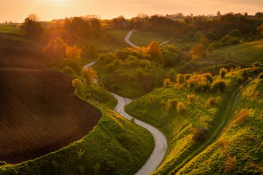 The last rays of sunshine in Pondzie. Swietokrzyskie Voivodeship, Stradow, Poland. Landscape of Ponidzie. Polish field in spring.  clipart