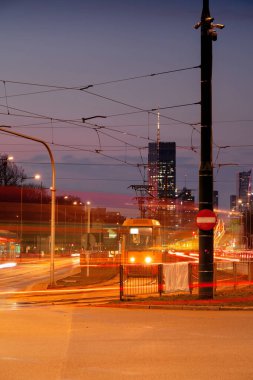 Varşova alacakaranlıkta, uzun pozlama, gökdelen Polonya 'nın başkenti. Polonya 'nın başkentinde tramvaylar. Şehir trafiği.