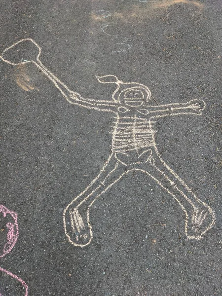 Chalk outline and bones drawn on pavement