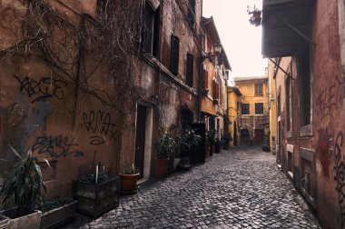 Roma 'nın eski bir caddesinin manzarası. Duvarları grafiti yapılmış. Sokakta kimse yok.