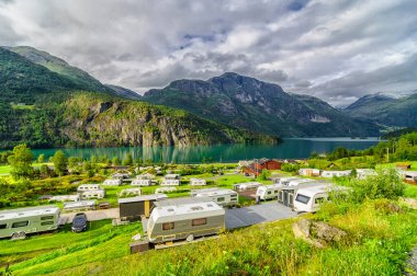 Norveç 'te bir gölün yanında kervanlarla kamp yapmak.