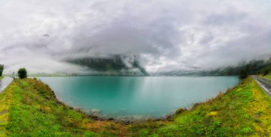 Mavi ve turkuaz su Norveç 'te bir fiyortta, çok fazla bulut ve sis var.