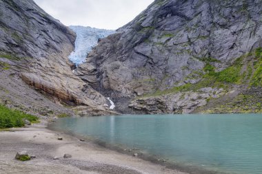 Bir buzulun manzarası ve Norveç 'teki buzulun erimiş suyundan akan bir nehir.