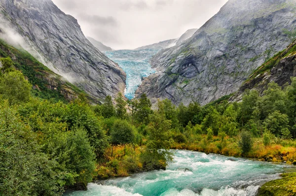 landscape of a glacier and a river from the melted water from the glacier in Norway