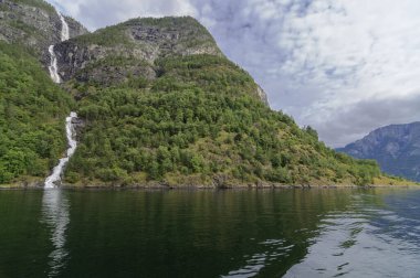 Norveç 'te yaz boyunca bir fiord' un yanındaki dağda bir şelale.