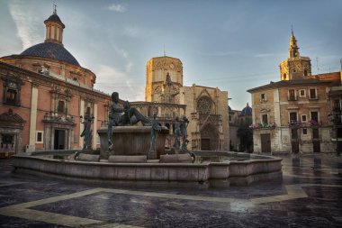 Valencia Katedrali 'nin olduğu meydan ortada bir çeşme ve şafakta başrahip evi.