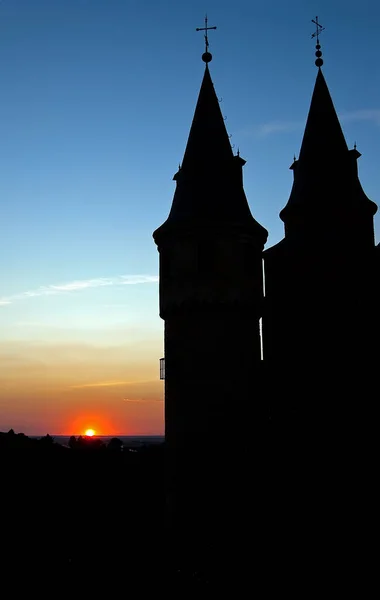 back light of the towers of the Alcazar of Segovia with the Sun setting on the background