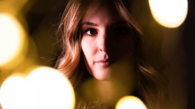 portrait of a beautiful young woman with long hair, with sparklers infront 