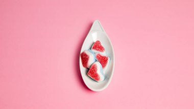 top view of delicious hearth gummies on pink background