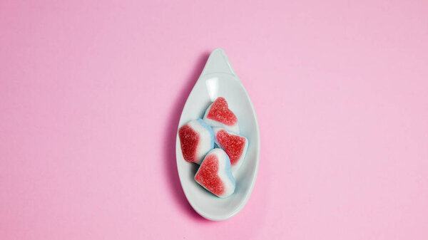 heart shaped candy on pink background