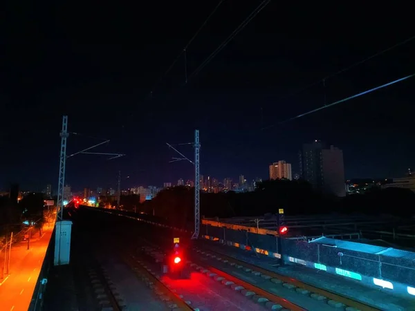 Demiryolu Şehrin Arka Planında Karanlık Gökyüzünde Gece Boyunca Takip Eder — Stok fotoğraf