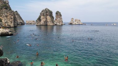 a beautiful shot of a rocky beach with rocks and sea on the background of the blue water