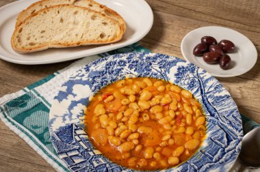 Homemade bean soup with vegetables . Greek bean soup with tomatoes, carrots, celery, and onions. Fasolada