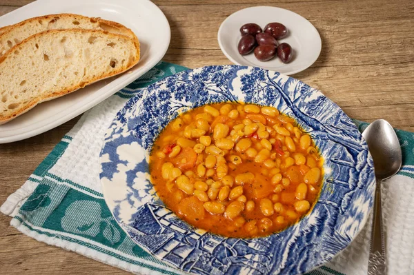 Homemade bean soup with vegetables . Greek bean soup with tomatoes, carrots, celery, and onions. Fasolada