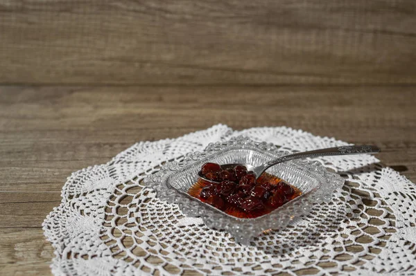 Ekşi kiraz kaşığı tatlı servis edilir, geleneksel şekilde, küçük bir tabakta bir kaşık dolusu