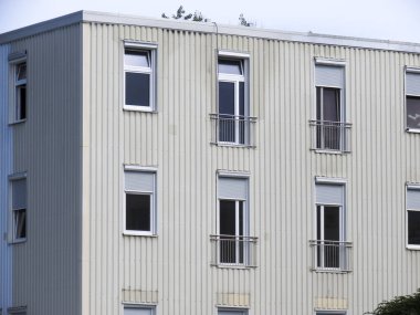 Pencerelerinde jaluzi olan modern konut binası.