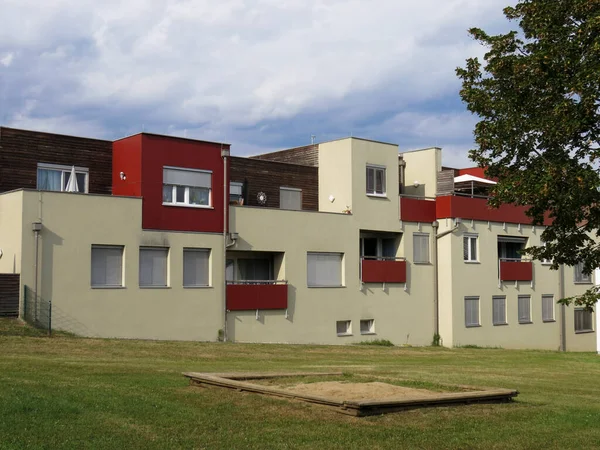Yeni bir apartmanın arka planında çocukların kum havuzu..