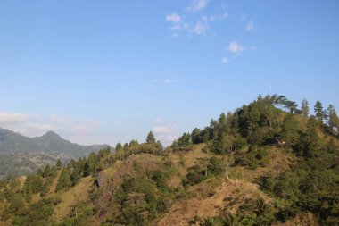 Dağları ve mavi gökyüzü olan güzel bir manzara.