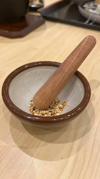 Tahta masada bir kase pirinç ve tokmak.