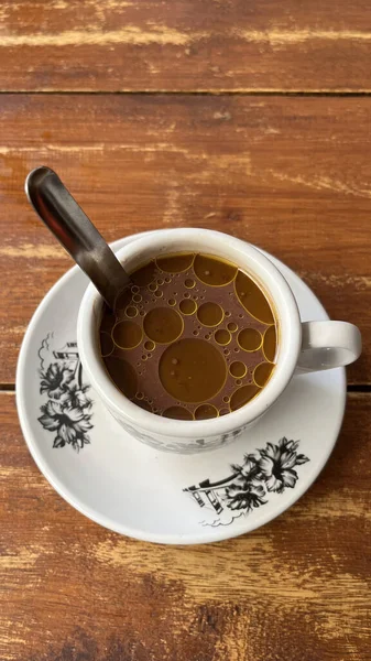 Tahta masada bir fincan tereyağlı kahve.