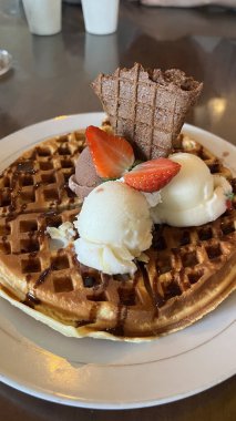 Çikolata soslu waffle, vanilyalı, çikolatalı dondurma ve çilekli.
