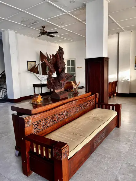 Geleneksel oturma odası içi ahşap kanepe, yelpaze ve ahşap antika süslemelerle dolu.