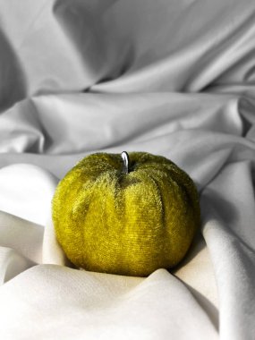 Beyaz tekstil arka planında kumaş yeşili balkabağı. Üst Manzara. Cadılar Bayramı el yapımı balkabakları, dikiş..